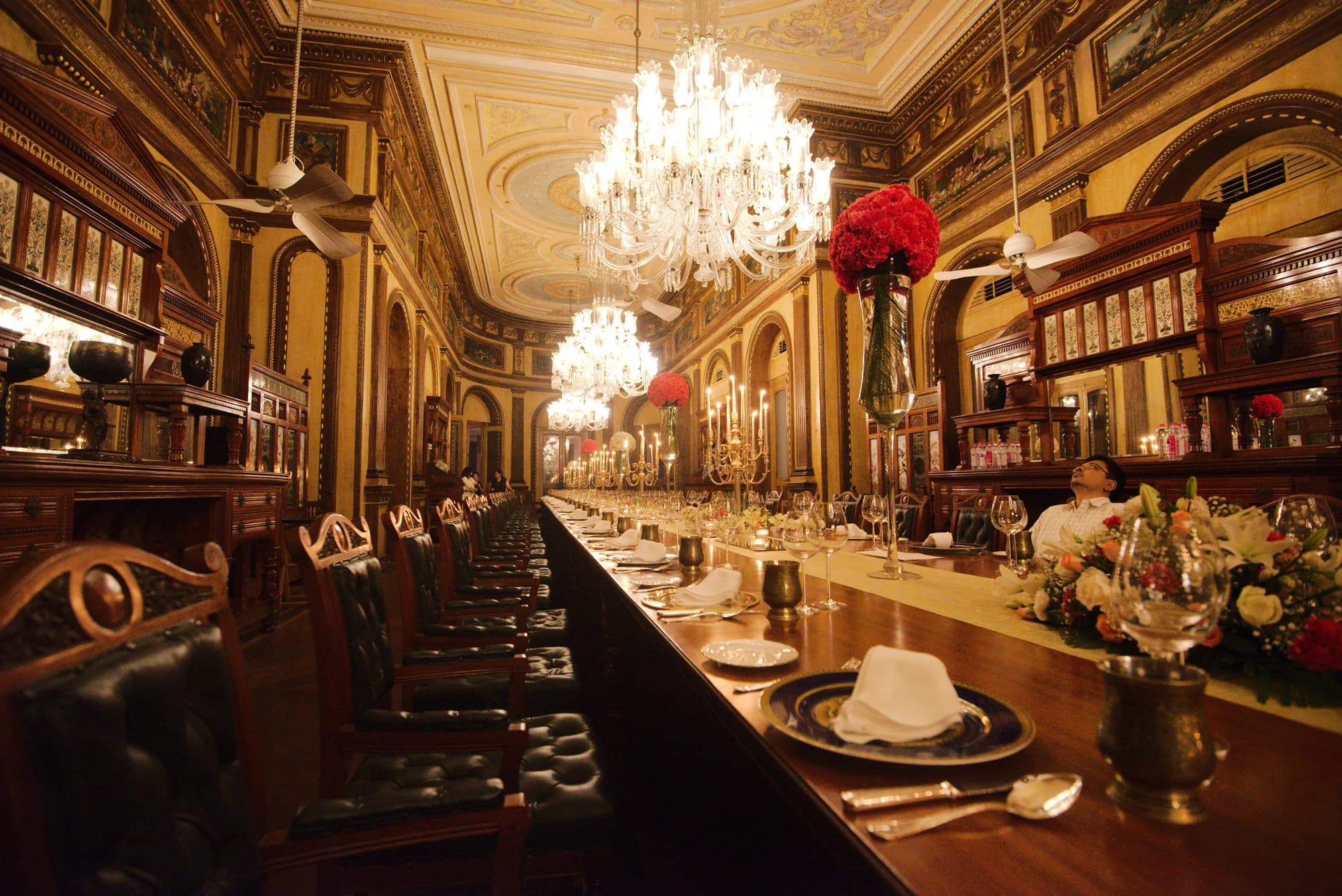 The 101-seat dining table — the world's longest, stretching the entire length of the Banquet Hall beneath chandeliers of Venetian crystal, Sèvres porcelain and Baccarat crystal gleaming at every place setting