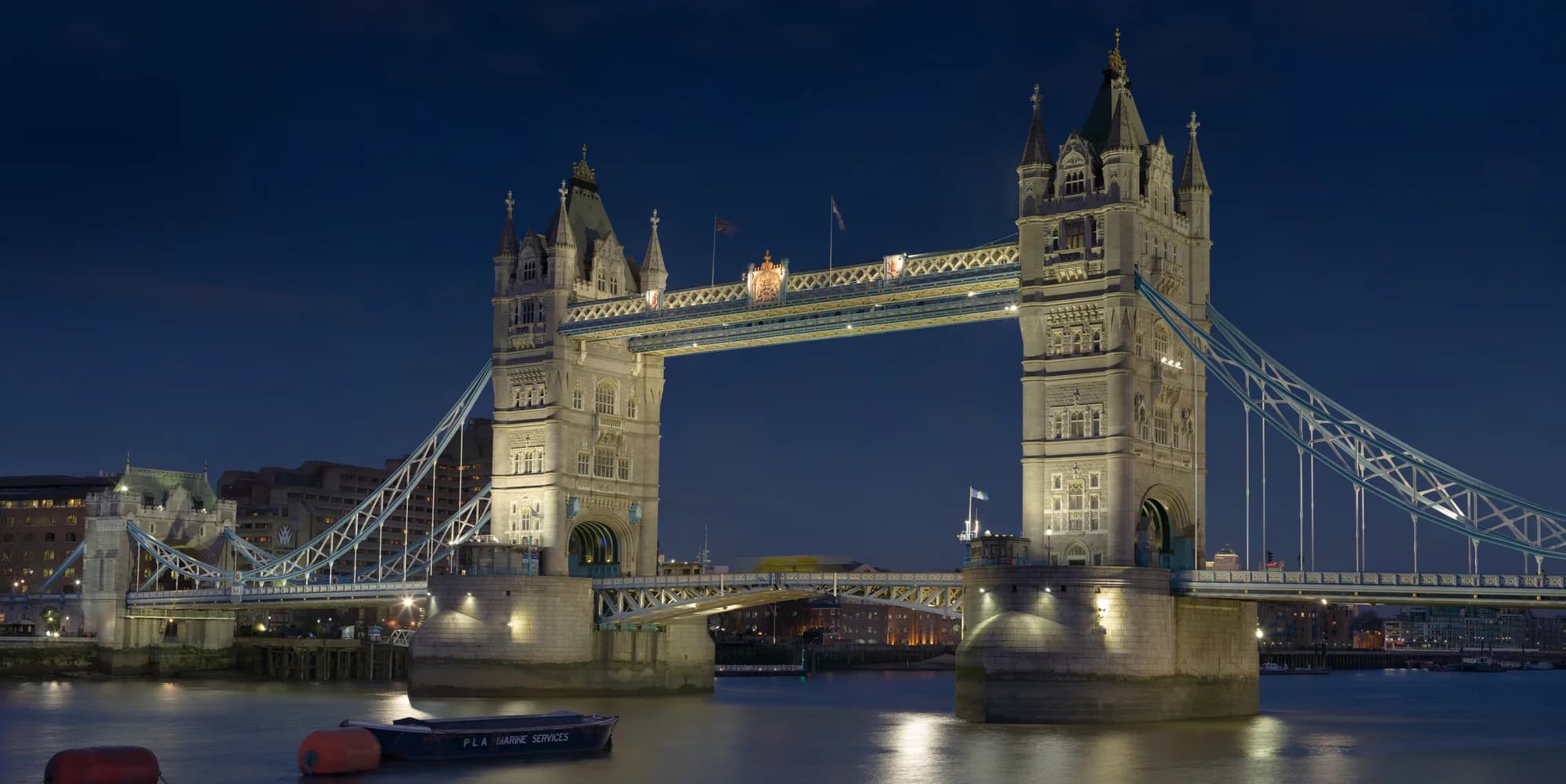 The Palace of Westminster and Big Ben at blue hour — the Mother of Parliaments reflected in the Thames, the London Eye a modern counterpoint on the opposite bank, two thousand years of history compressed into a single river bend, the sky a deepening wash of indigo and rose