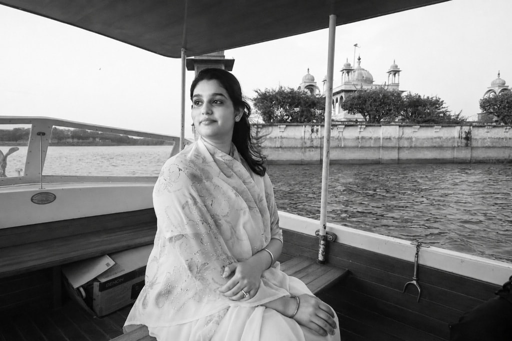 Princess Shivanjali Kumari Dungarpur seated in a boat on Dungarpur lake with Udai Bilas Palace in background